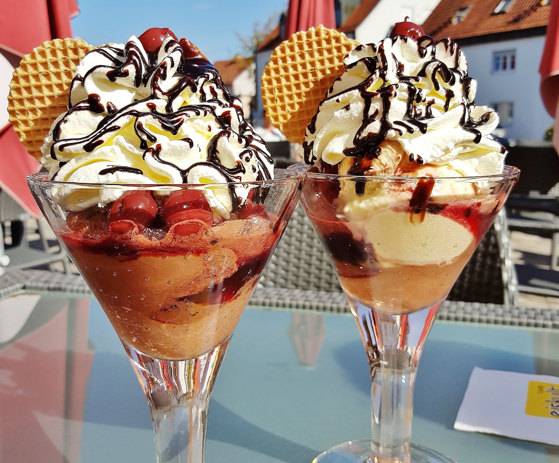 Ice cream with chocolate syrup and cherries in a goblet.